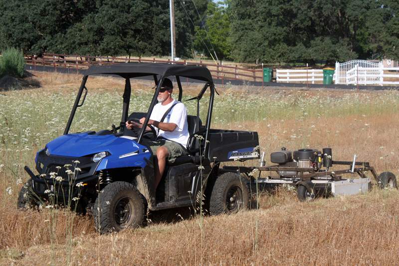 Polaris RANGER EV towing a Kunz Rough Cut Field Mower